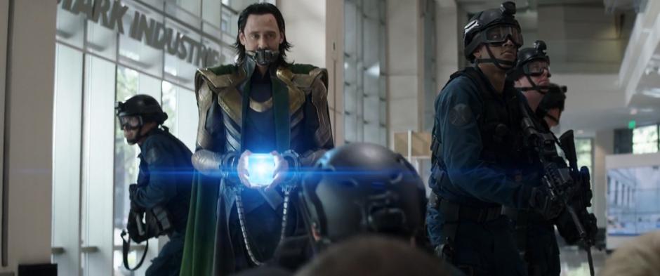 Loki picks up the Tesseract that has spilled onto the ground.