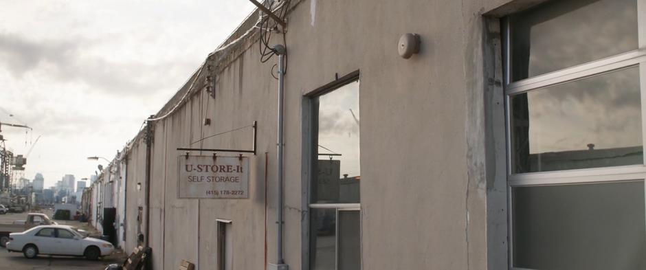 Establishing shot of the exterior of the storage facility with its sign.