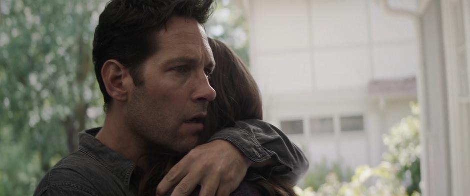 Scott hugs his now older daughter Cassie on the steps outside the house.