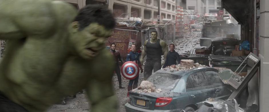 Scott, Steve, Bruce, and Tony watch as the Hulk from the past runs past smashing stuff.