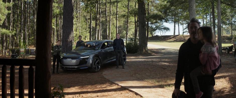 Tony carries Morgan back to the house while Natasha, Scott, and Steve stand by their car waiting to talk to him.