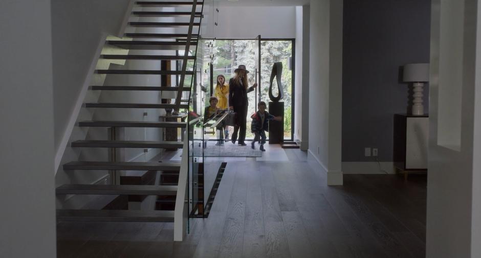 The boys run ahead as Emily leads Stephanie through the front door.