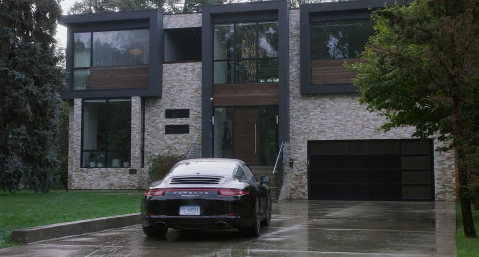 Emily pulls her car into the driveway of her house in the rain.