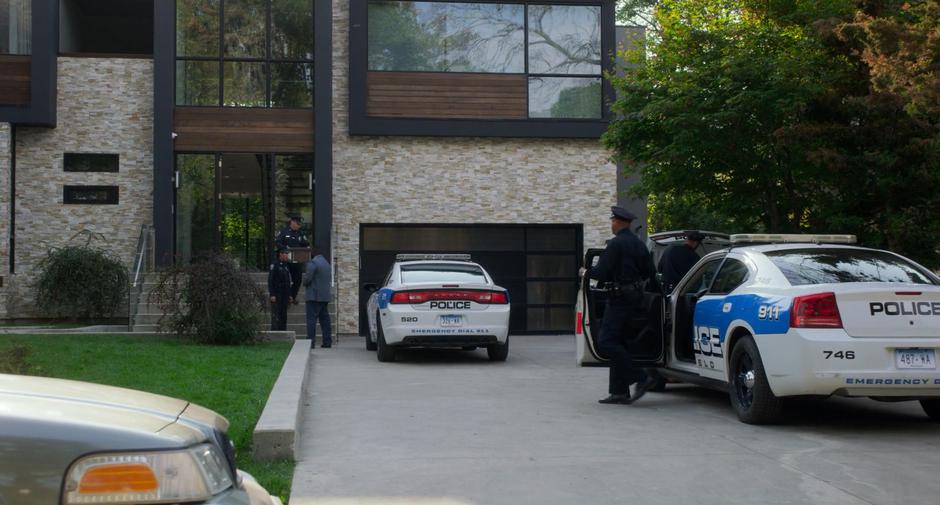 The police remove boxes of evidence from the house under Detective Summervile's supervision.