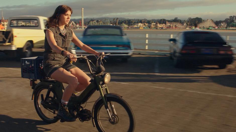 Charlie rides her bike down the wharf while listening to music.