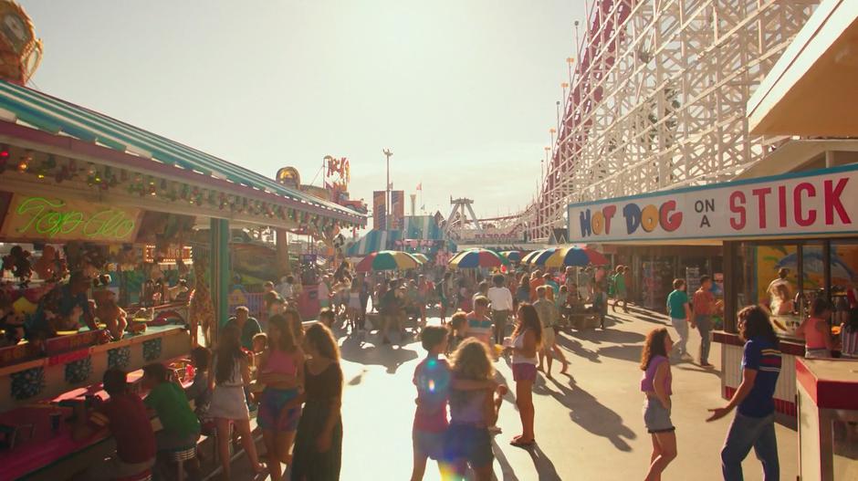 A crowd of people spend time around the boardwalk.