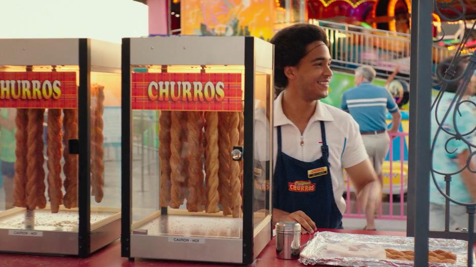 Memo smiles at Charlie as she walks past his churro stand.