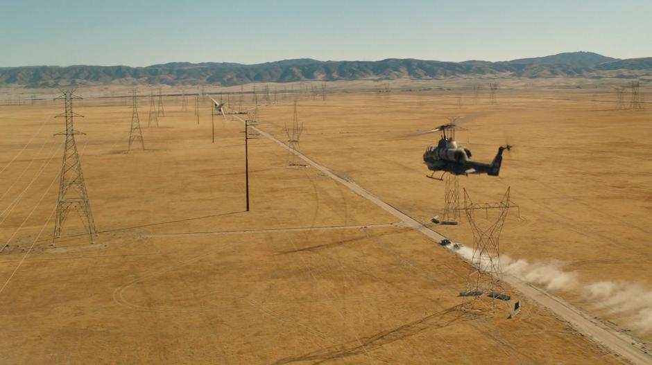 A jet and helicoper follow Dropkick and Shatter down the dirt road towards the military road block.