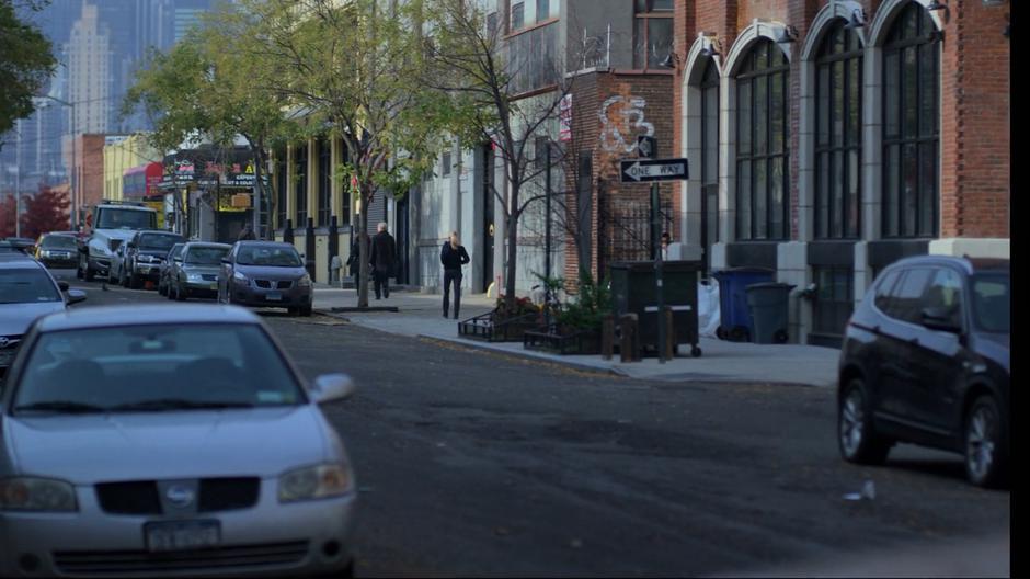 Trish walks down the sidewalk across the street from Jessica.