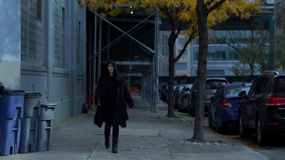 Jessica follows Trish down the street from the distance.