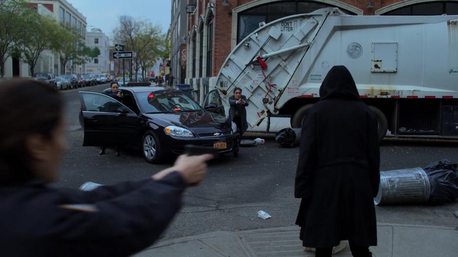 A police officers approaches to cuff Jessica while Detectives Imada and Defford hold her at gunpoint.