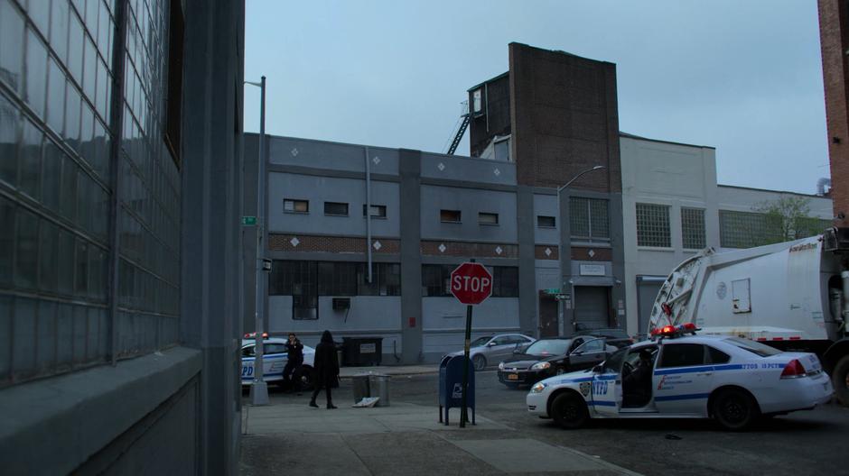 Several police cars surround Jessica as she reaches the street corner.