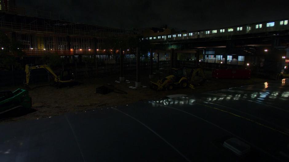 A train drives past as Erik waits in the construction lot.