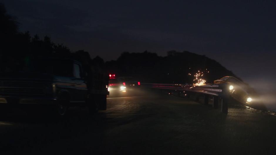 Bumblebee scrapes against the outside of the railing while the police car swerves around a truck full of hay bails.