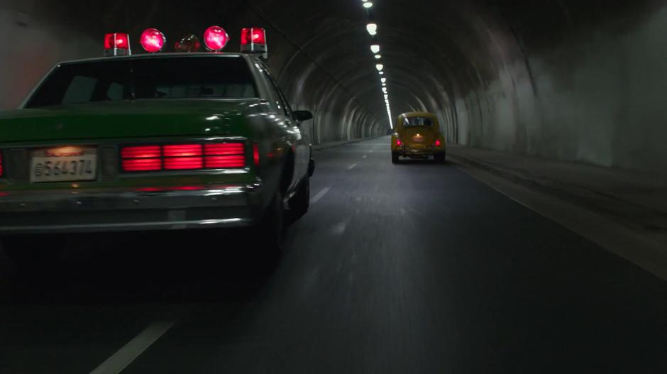 The police car drives into the oncoming lane in an attempt to overtake Bumblebee.