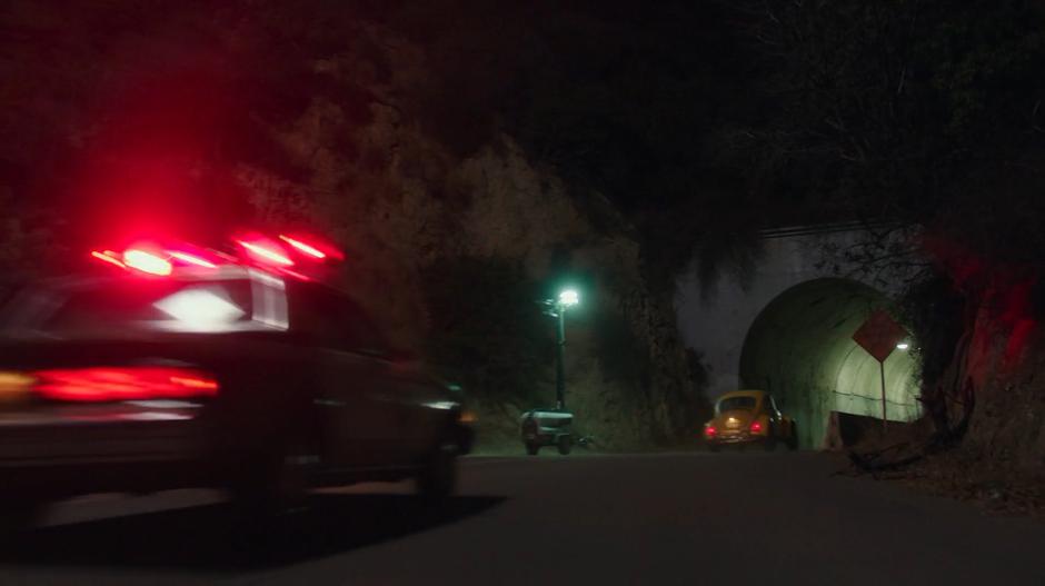 The police car chases Bumblebee into a tunnel at night.