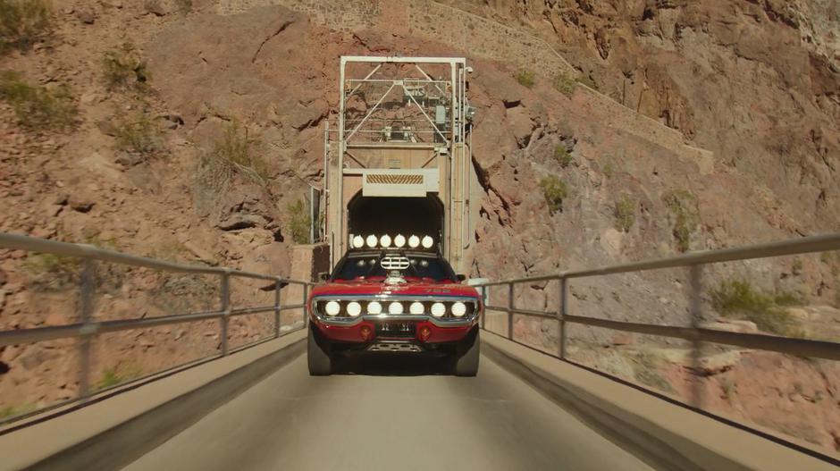 Shatter drives out of the tunnel from the secret base and across a bridge.