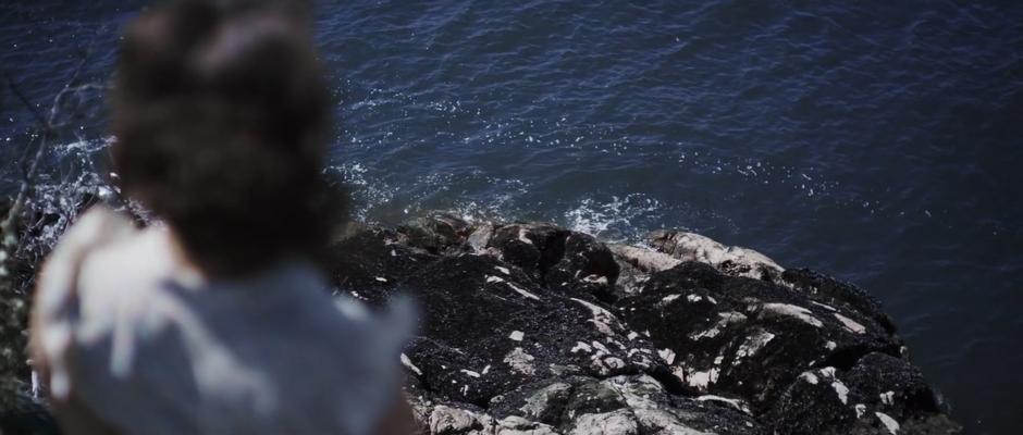 Alice stands at the edge and looks down at the water.