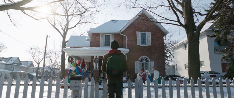 Billy stands outside the gate looking at the house where his mother may live.