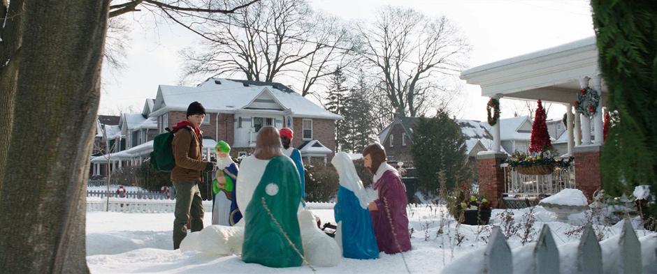 Billy glances as the relegious decorations on the lawn as he approaches the house.