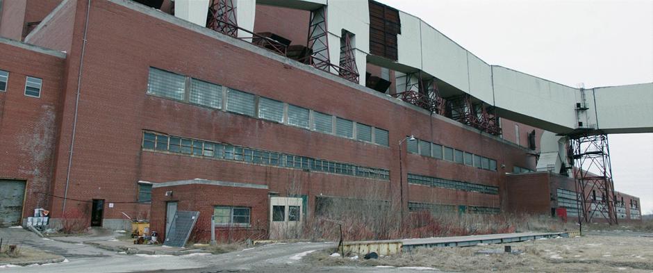 A light shines through the windows of the abandoned building from Billy's lightning.