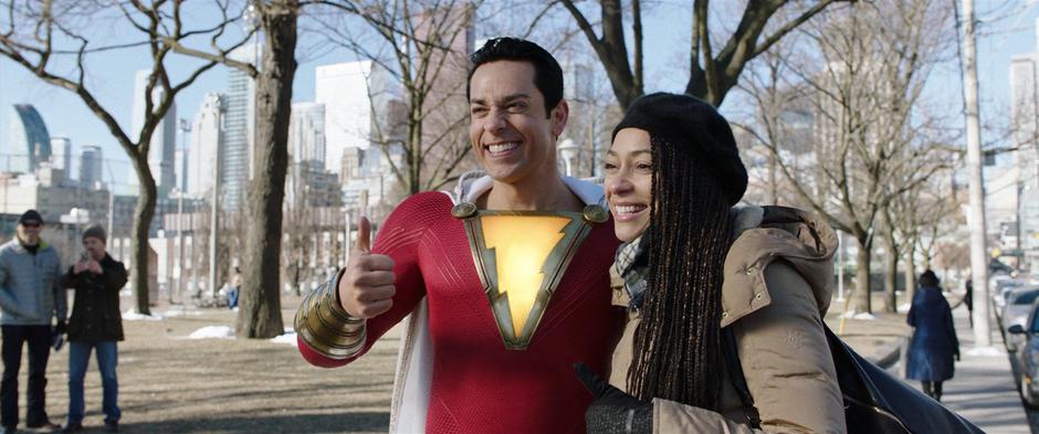 Billy gives a thumbs up to the camera while posing for a photo with a woman in the park.