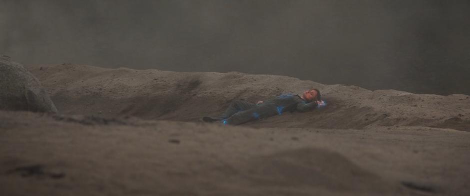 Carol lies on the ground glowing with blue energy after the explosion.