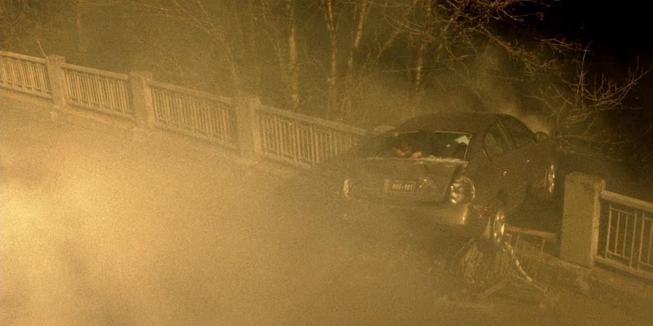 Young Kate climbs through the back window of the car which is hanging over the edge of the bridge.