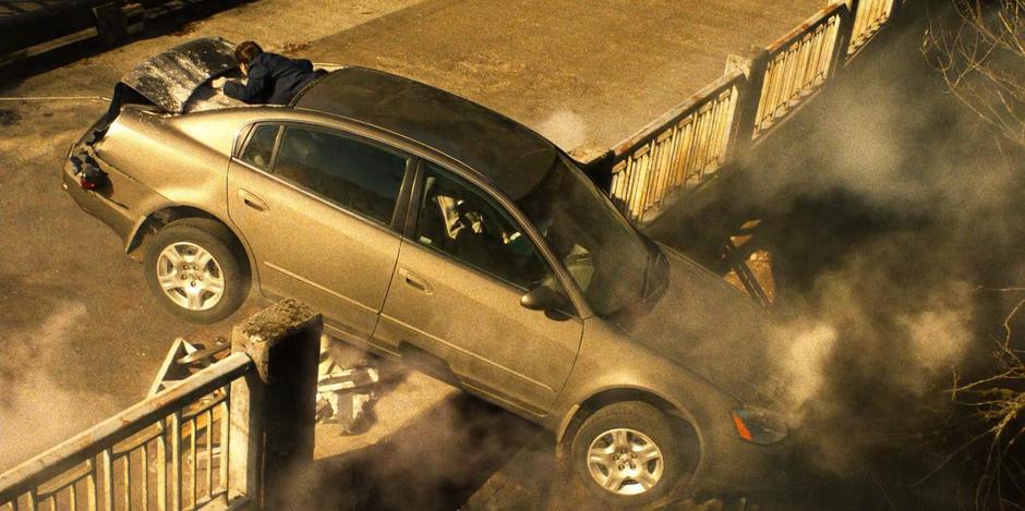 Young Kate climbs out of the back window of the car as it hangs precariously on the edge of the bridge.