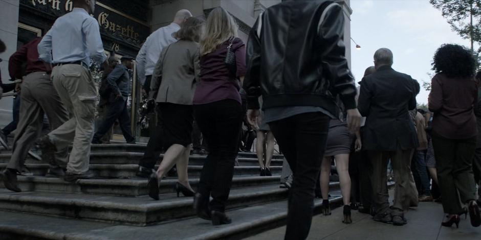 Kate walks towards a crowd of people around the steps of the Gazette offices.