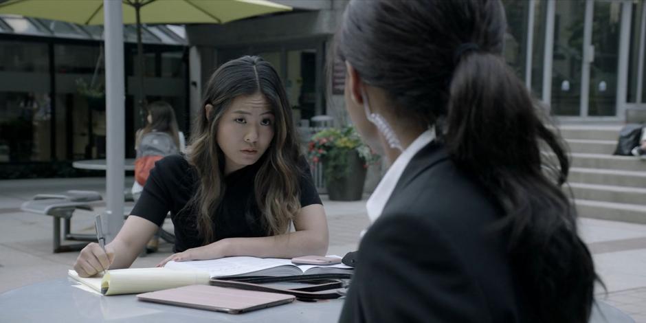 Mary looks up from her study materials at Sophie when Sophie asks about Kate.