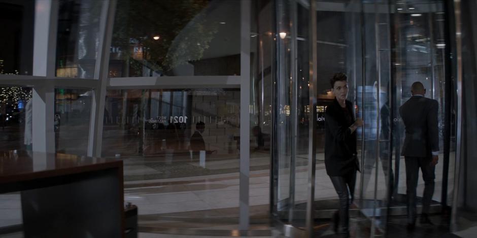 Kate enters the lobby through the revolving door.