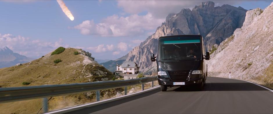 A fireball comes towards the bus as it drives along a winding mountaintop road.