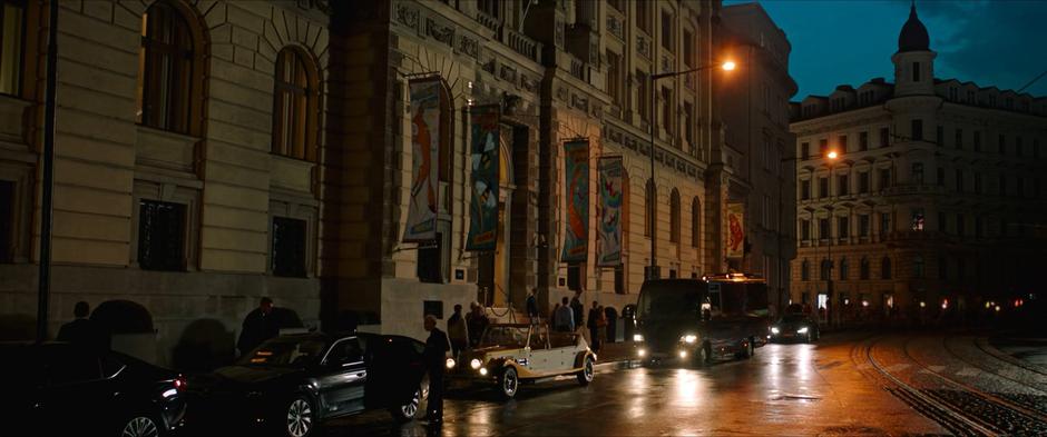 The bus parks in front of the imposing exterior of the hotel.