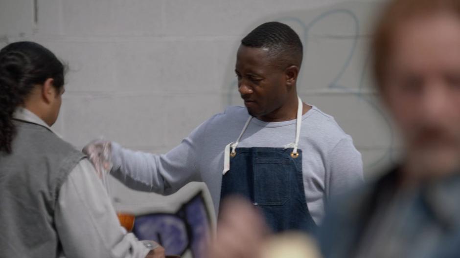 A man serves soup to people in line.