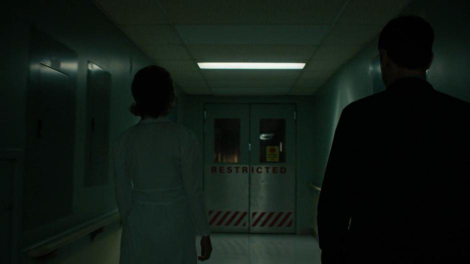 The nurse leads Harry into the restricted area in the basement.