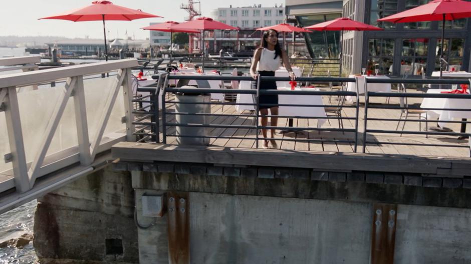 Kelly stands at the railing and watches as Alex saves people from the collapsing crane.