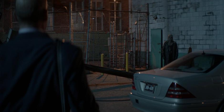 Angus Stanton spots a man in an executioner's mask standing next to the fallen electrical pole.