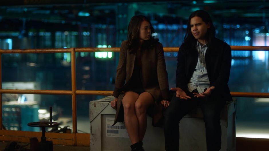 Kamilla sits on a crate with Cisco as he talks about his feelings regarding Cynthia's death.