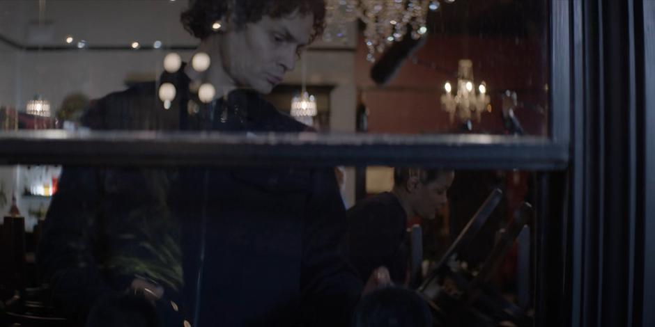 A worker replaces the broken window at the front of the restaurant.