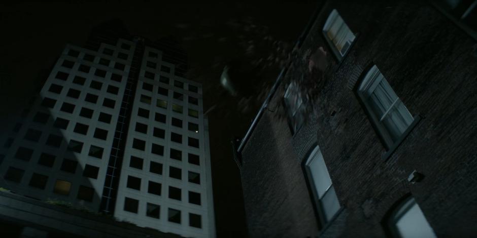 Julia Pennyworth flies through the air after being blasted through the wall by the anti-Batwoman gun while disguised as the vigilante.