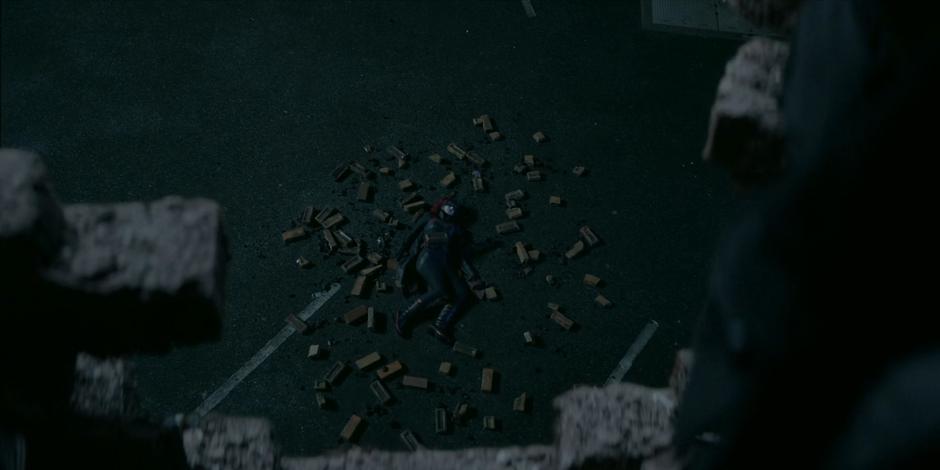 Julia Pennyworth lies in a pile of bricks in the parking lot below disguised as Batwoman.