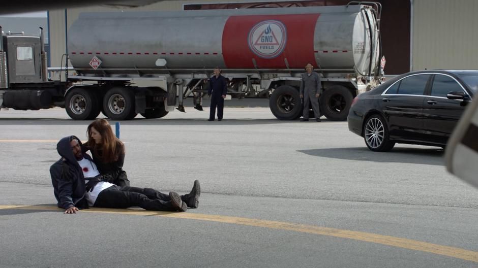 Andrea clutches Russell dying body while two technicians watch them passionlessly from the distance.