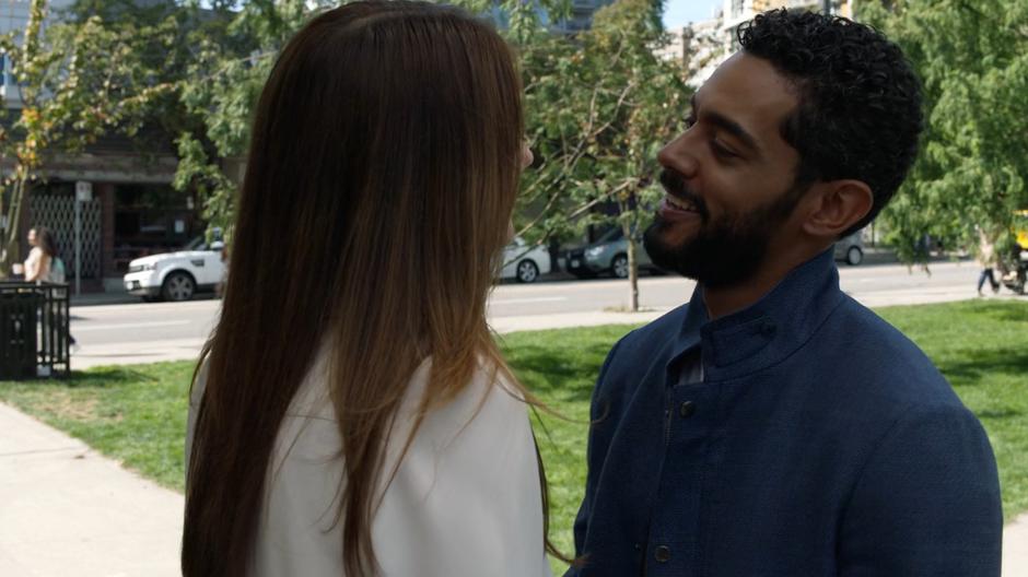 Russell smiles at Andrea while standing close.