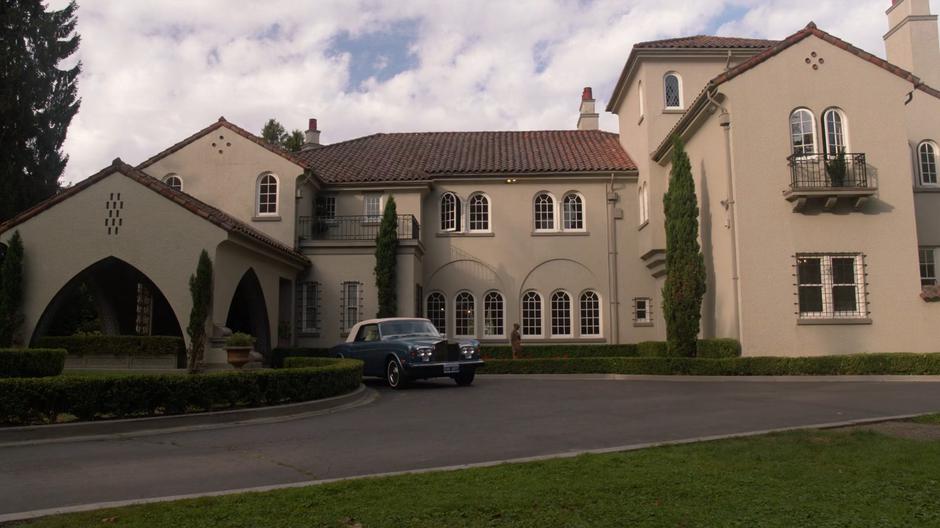 Establishing shot of the mansion with a car sitting in the driveway.