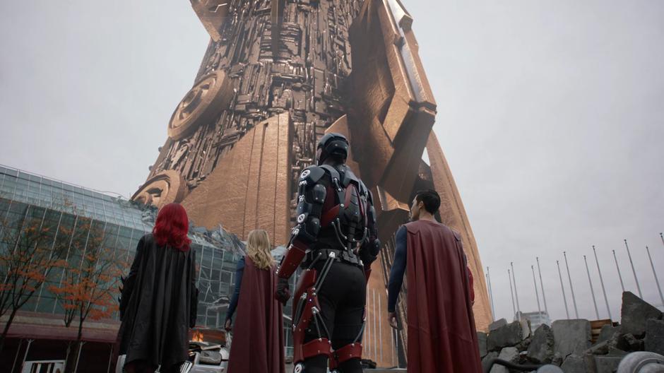 Kate, Kara, Ray, and Clark look up at the spire that has erupted from the ground.