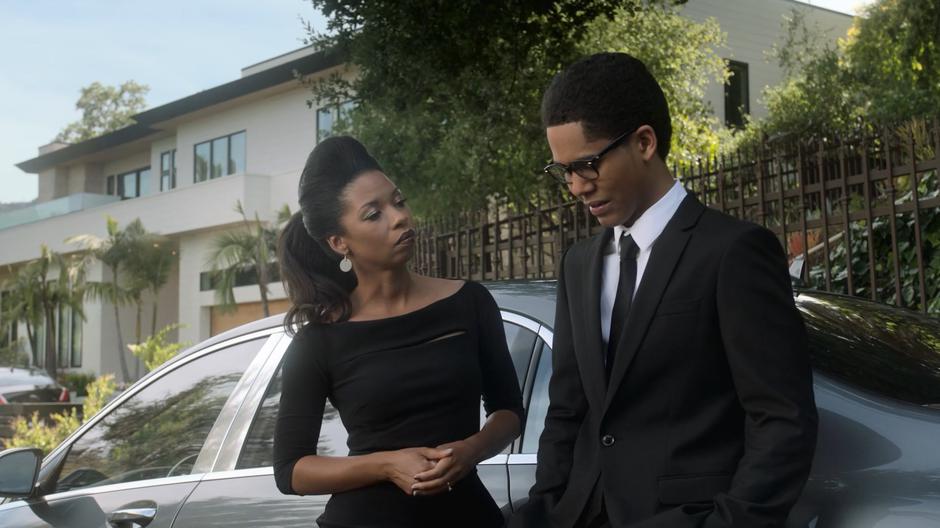 Catherine listens to Alex talk about his feelings as they lean against their car.