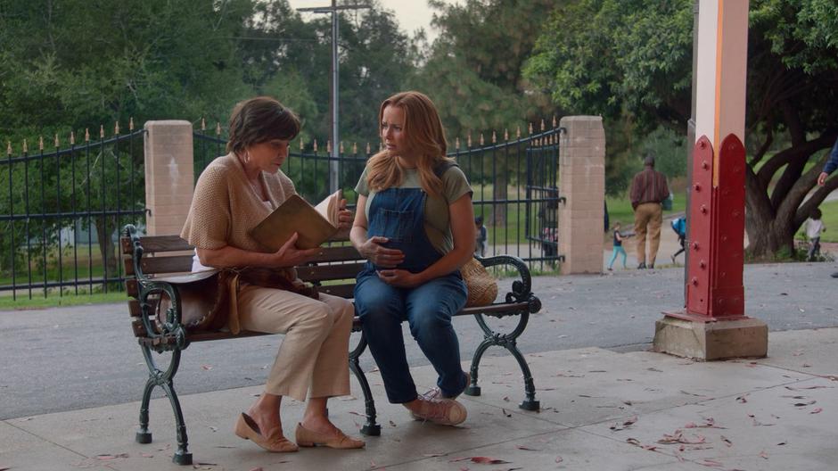 Leslie watches as Susan Ellerh pulls out her father's journal to show her a passage.