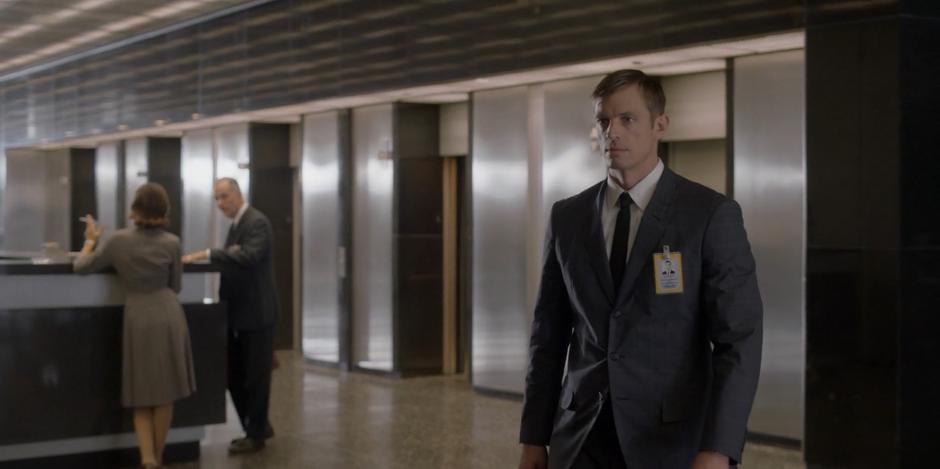 Ed walks to the reception desk in the lobby.