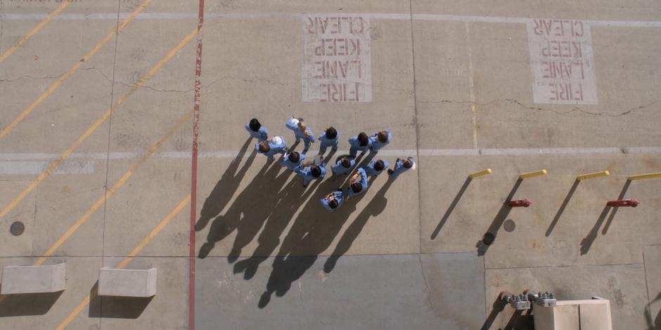 The ASCANs stand in a group next to the hanger and watch as one of their group flies a jet.